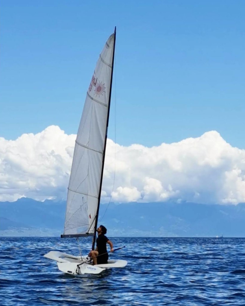 Marc sailing a dinghy on calm water